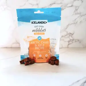 A blue, white, and orange color package of soft chew nibbles for dogs