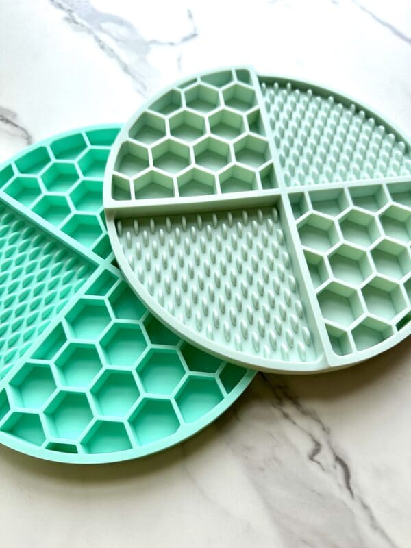 Two green silicone cleaning mats with different textures.