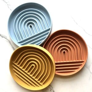 Three silicone trays with rainbow design.